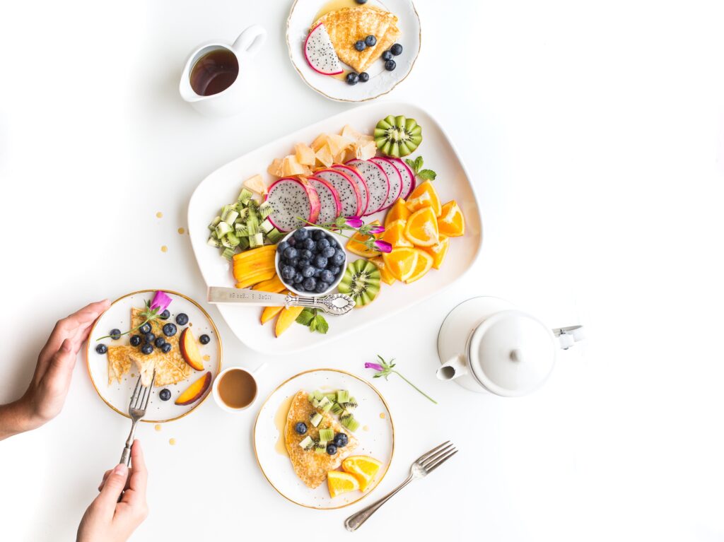 Image décorative : Assiettes sur fond blanc, contenant des crêpes et des fruits aux couleurs pleines d'énergie et appétissantes. Source : Unsplash titre original : brooke-lark-lcZ9NxhOSlo-unsplash